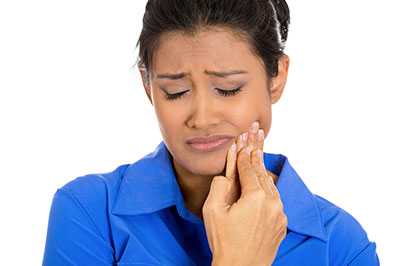 Woman with hand on face, appearing concerned or distressed.